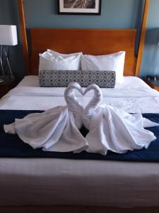 a white bed with white sheets and pillows on top of it at Rockland Harbor Hotel in Rockland