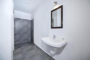 a white bathroom with a sink and a mirror at Apartament Villa Clara in Lądek-Zdrój