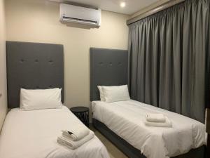 um quarto com duas camas com toalhas em 77 On Burger em Polokwane