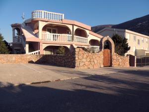 a large house with a stone wall and a building at Tea-Dream house in Cesarica