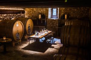 a table in a wine cellar with barrels at Massimago Wine Relais in Mezzane di Sotto