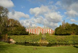 a large red brick building in the middle of a field at Bosworth Hall Hotel & Spa in Market Bosworth