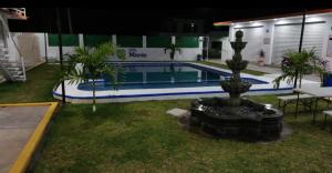 a swimming pool with a fountain in front of a building at Hotel Villa Marán Chachalacas Ambiente Familiar in Chachalacas