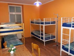 a room with three bunk beds and a table at Monterooms Vienna Schönbrunn 10 minutes to downtown in Vienna