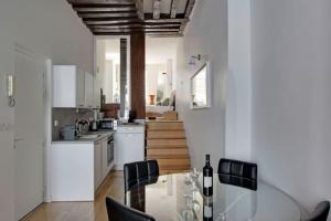 a kitchen with a table and chairs and a staircase at Luminous Loft in Saint-Germain des Prés in Paris
