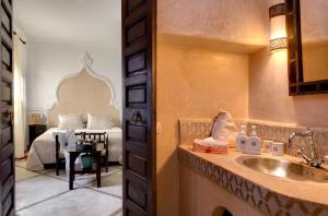 ein Badezimmer mit einem Waschbecken und ein Schlafzimmer mit einem Bett in der Unterkunft Marrakech Riads, Angsana Heritage Collection in Marrakesch