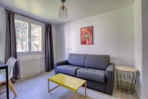 a living room with a couch and a table at Magnificent Studio Near The Canal De L'ourcq in Paris