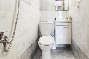La salle de bains est pourvue de toilettes blanches et d'un lavabo. dans l'établissement Charlot House, à Thessalonique