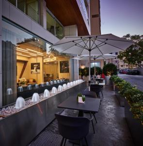 een restaurant met tafels en stoelen en een parasol bij Sodeco Suites in Beiroet