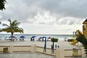a beach with umbrellas and chairs and the ocean at Dover Beach House By-BLR in Christ Church