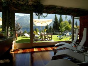 a room with a view of a patio with an umbrella at Hotel Belvedere in Folgarida