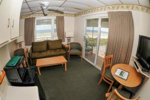 sala de estar con sofá, mesa y TV en Friendship Oceanfront Suites en Old Orchard Beach
