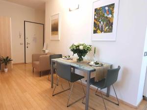 Corso Vercelli Apartment في ميلانو: غرفة طعام مع طاولة مع كراسي وورود عليها