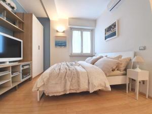 Corso Vercelli Apartment في ميلانو: غرفة نوم فيها سرير وتلفزيون