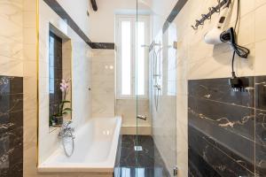 a bathroom with a tub and a glass shower at Elegante Casa Liberty in Milan