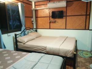 - une chambre avec 2 lits dans une chambre avec une fenêtre dans l'établissement ต้งโฮมหละปูน ณ ตูบคำ, à Lamphun