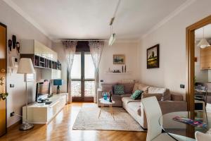 sala de estar con sofá y TV en Hostly - Family Home Strada dell'Olio - Brand new 2BR, 2 Bathrooms with AC, en Cascina