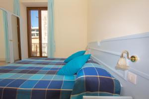 a bedroom with a bed with blue pillows at Sine Tempore in Sorrento