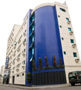 a building with a blue wall on the side of it at Hotel Domani in Guarulhos