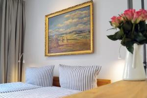 a vase of flowers on a table with a painting on the wall at Apartment Dompredigergasse in Naumburg