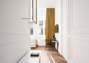 a hallway with white walls and a door with a table at Mariënhage Boutique Hotel in Eindhoven