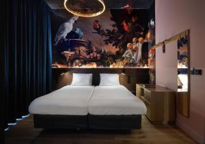 a bedroom with a bed with a painting on the wall at Mariënhage Boutique Hotel in Eindhoven +174 photos
