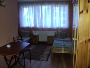 sala de estar con mesa, sofá y ventana en Hotel Materhorn en Razlog
