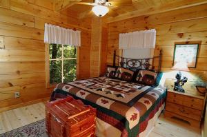 - une chambre avec un lit dans une cabane en rondins dans l'établissement #2903 Abundantly Blessed, à Pigeon Forge