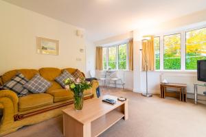 a living room with a couch and a table at The Garden Apartment in Bramhall