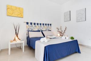 una camera con un letto blu e bianco e un tavolo di MILLEBOLLEBLU APARTMENTS a Lido Marini