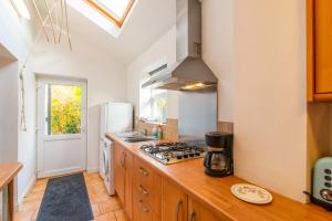 a kitchen with a stove and a refrigerator at The Garden Apartment in Bramhall