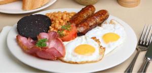 a plate of breakfast food with eggs beans and bacon at Europa Gatwick Hotel & Spa in Crawley