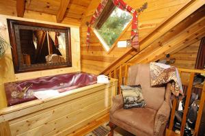a room with a tub and a chair in a cabin at #754 Bear Hugs in Gatlinburg