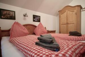 a bed with red and white checkered sheets and pillows at Almhaus Bachmann in Sonnenalpe Nassfeld