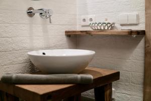 a white bowl sink on a wooden table in a bathroom at Almhaus Bachmann in Sonnenalpe Nassfeld +63 photos