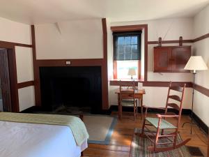 1 dormitorio con 1 cama y chimenea en Shaker Village of Pleasant Hill, en Harrodsburg