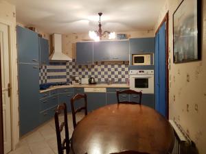 cocina con mesa de madera y armarios azules en Gîte en Baie du Mont Saint Michel, en Cherrueix