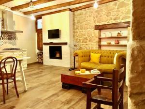 a living room with a yellow couch and a kitchen at MODERN ELEGANCE SUITE B&B in Larino
