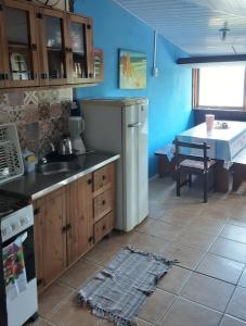 uma cozinha com um frigorífico branco e uma mesa em Mona lisa em Florianópolis