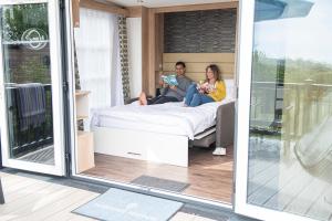 a man and woman sitting on a bed in a room at Brighton Experience Freedom Glamping in Brighton & Hove