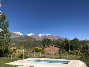 una piscina en un campo con montañas en el fondo en Casa Montaña Valle del Sol en Potrerillos
