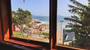 - une vue sur la plage depuis la fenêtre dans l'établissement Mona lisa, à Florianópolis
