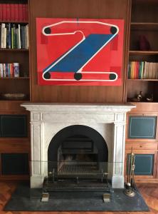 a fireplace with a red and blue painting above it at Estrelícia in Porto