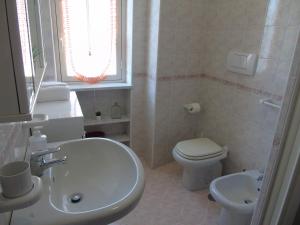 a white bathroom with a sink and a toilet at TraMonti e Mare in Tramonti