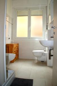 uma casa de banho com 2 lavatórios, um WC e uma janela em Residenza Abbo em Diano Marina