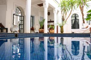 a swimming pool in a house with a villa at Riad Bellamane Marrakech in Marrakesh