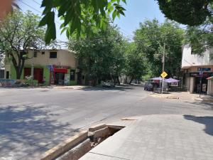 an empty street in a town with trees and buildings at Luminoso Departamento Mendoza in Mendoza