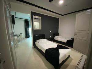 突尼斯Hôtel le calife的有两张床和一张桌子的酒店房间