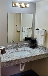 a bathroom with a sink and a large mirror at Travelodge by Wyndham Albuquerque West in Albuquerque