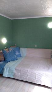 ein großes Bett in einem Zimmer mit grüner Wand in der Unterkunft Гостевой таунхаус in Demidov